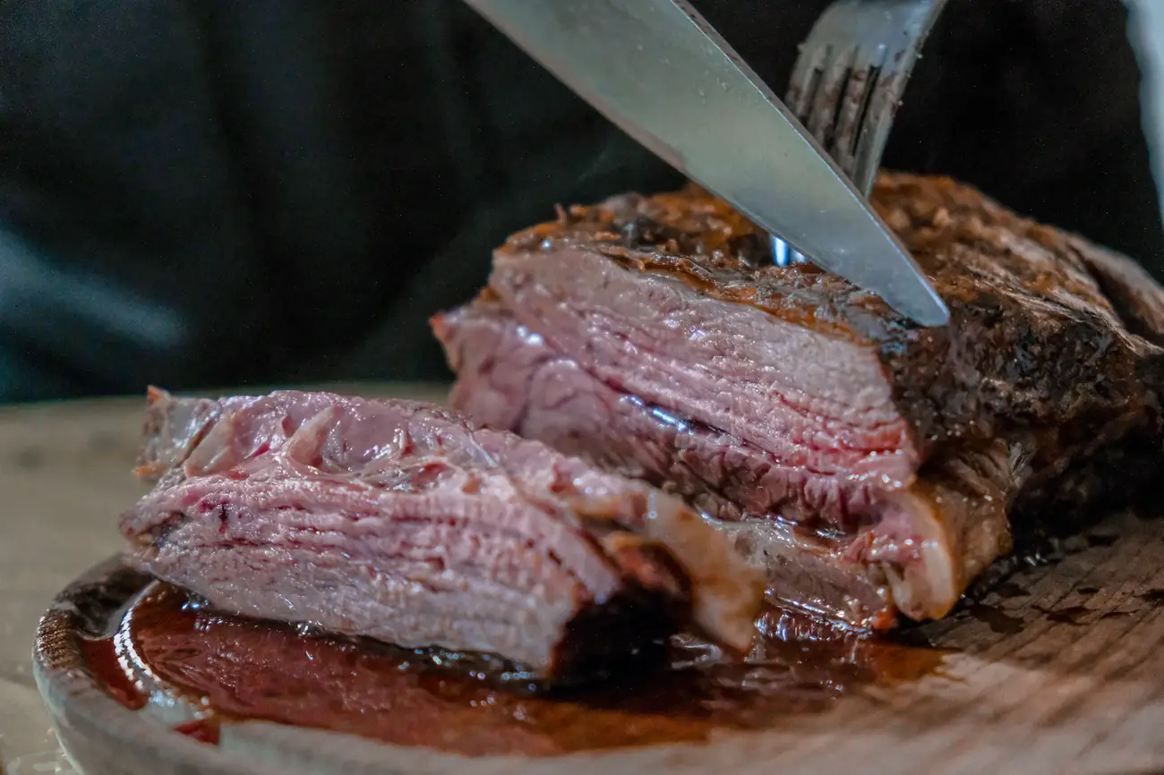 Corte de carne asada rebanado sobre una tabla de madera